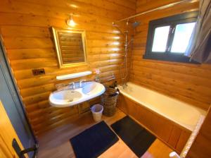 y baño de madera con lavabo y bañera. en Chalet Vue Panoramique en Bolquere Pyrenees 2000