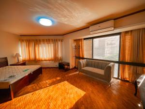 馬尼拉的住宿－Spacious Luxury 3BR at the Heart of Makati，一间卧室配有一张床、一张沙发和一个窗口