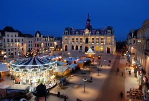 a city with a christmas market in front of a building at Les Studios de Clément in Poitiers