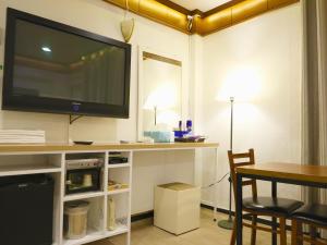 a living room with a flat screen tv on a wall at Goodstay Andong Park Hotel in Andong