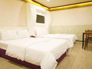 sypialnia z 2 łóżkami, stołem i krzesłami w obiekcie Goodstay Andong Park Hotel w mieście Andong