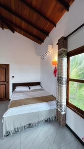 1 dormitorio con cama y ventana en The lookout lodge, en Tangalle
