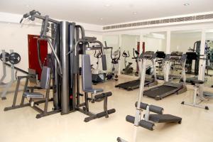 a gym with a lot of tread machines at Hotel KPM Tripenta in Palakkad