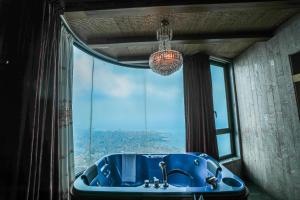 Baño con bañera azul frente a una ventana en Bay Lodge Boutique Hotel, en Jounieh