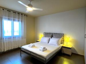 Infinity Horizon Syros Apartment في Lazaréta: غرفة نوم بسرير ومصباح ونافذة