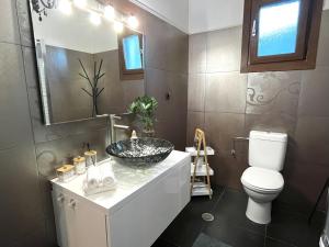 a bathroom with a sink and a toilet and a mirror at Infinity Horizon Syros Apartment in Lazaréta +30 photos