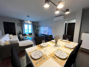 a dining room and living room with a table and chairs at Infinity Horizon Syros Apartment in Lazaréta