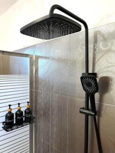El baño incluye ducha con cabezal negro. en Infinity Horizon Syros Apartment, en Lazaréta
