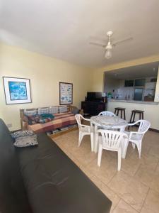 sala de estar con sofá, mesa y sillas en Apto Pé na Areia - Wi-Fi Gratuito - Tranquilidade à beira mar, en Cabo Frío