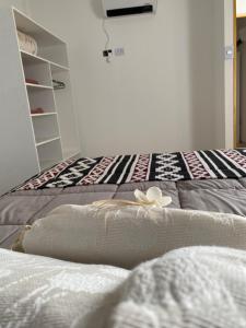 Dos camas en una habitación con una flor blanca. en Departamento Navarro 2 en Malargüe