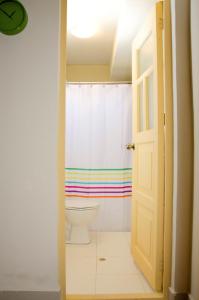 a bathroom with a toilet and a rainbow shower curtain at Historical Center Apartments in Cusco
