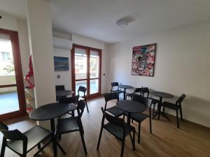 grupa stołów i krzeseł w pokoju w obiekcie Monti Guest House Alghero w mieście Alghero
