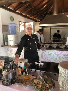 kobieta stojąca w kuchni przygotowująca jedzenie w obiekcie Ecco Village - Serrambi w mieście Porto de Galinhas