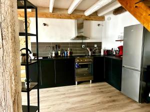 uma cozinha com armários verdes e um frigorífico de aço inoxidável em Crocoloft Nimes Centre em Nîmes