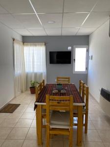 a dining room with a table and chairs and a television at Departamento Navarro 2 in Malargüe