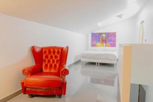een rode stoel en een bed in een kamer bij Élégant 2 pièces proche de Paris et Disneyland in Neuilly-sur-Marne