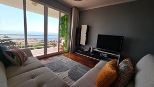 a living room with a couch and a flat screen tv at Seaview Relax Apartment in Caniço