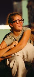 a man with glasses sitting on a chair at Hotel Poonam Pushkar in Pushkar