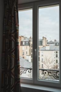 a window with a view of a city at La Maison Montparnasse in Paris