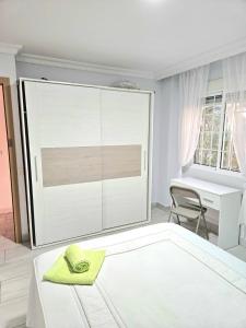 Habitación Privada a 15 min de la Playa/Piso في هويلفا: غرفة بيضاء مع سرير ومكتب