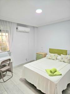 a white bedroom with a bed and a desk at Habitación Privada a 15 min de la Playa/Piso in Huelva