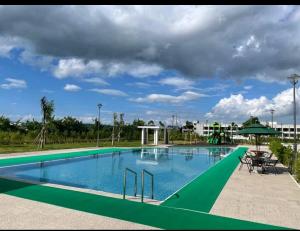 a large swimming pool with a green border at Condo in Clark Pampanga beside Hilton Hotel and Casino in Fort Stotsenburg