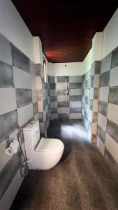 a bathroom with a white toilet in a room at The lookout lodge in Tangalle