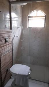 a bathroom with a toilet and a shower with a window at Pousada Manga Rosa in Paraty +57 photos