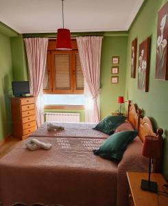 1 Schlafzimmer mit 2 Betten und grünen Wänden in der Unterkunft 21A02 Coqueto apartamento en la nieve con garaje in Felechosa