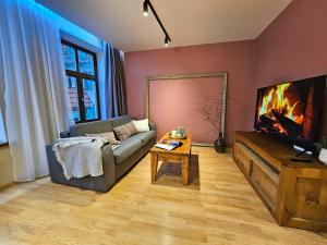 a living room with a couch and a flat screen tv at Silversmith's Residence in Old Riga in Riga