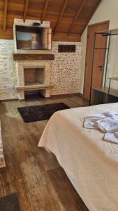 a bedroom with a brick fireplace and a bed at Pousada Vilas di Espanha in Monte Verde
