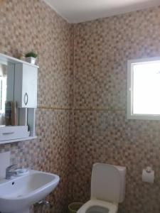 uma casa de banho com um WC branco e um lavatório. em maison à louer les grottes Bizerte Tunisie em Dar el Koudia