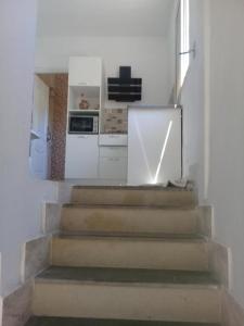 eine Treppe in einer Küche mit einem Herd und einem Kühlschrank in der Unterkunft maison à louer les grottes Bizerte Tunisie in Dar el Koudia