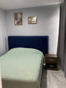 a bedroom with a blue bed and a night stand at Casa duplex aeropuerto/arena VFG in Guadalajara