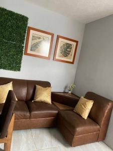 a living room with a brown leather couch at Casa duplex aeropuerto/arena VFG in Guadalajara