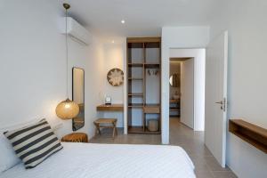 a bedroom with a bed and a desk in a room at La Chapelle Ouest & Grand suite in Agios Romanos