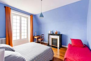 a blue bedroom with a bed and a fireplace at Villa La Côte du Chat in Hédé