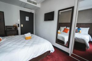 a hotel room with two beds and a mirror at La Maison Montparnasse in Paris