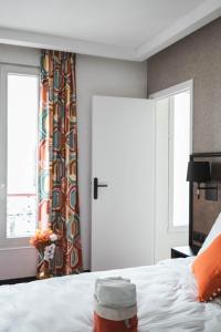 a bedroom with a white bed and a window at La Maison Montparnasse in Paris