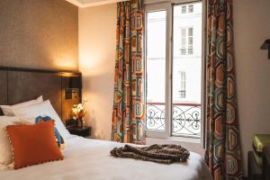 a bedroom with a bed and a large window at La Maison Montparnasse in Paris