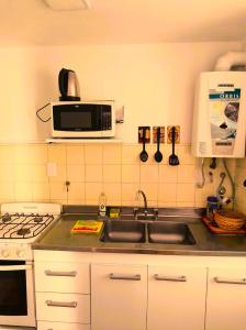 a kitchen with a sink and a microwave at Departamento en el centro de Córdoba in Cordoba