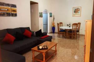 La Casita Vibbecanarias Tunte في سان بارتولومي: غرفة معيشة مع أريكة سوداء وطاولة