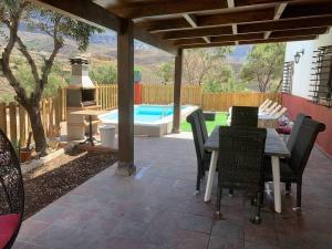 a patio with a table and chairs and a pool at La Casita Vibbecanarias Tunte in San Bartolomé