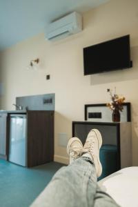 a person laying on a bed with their feet on a room at La Maison Montparnasse in Paris