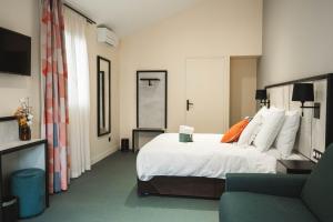 a hotel room with a bed and a couch at La Maison Montparnasse in Paris