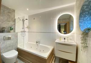 a bathroom with a tub and a toilet and a sink at Lune Cottage nestled between Lake District and Yorkshire Dales in Tebay