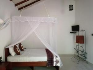 a bedroom with a bed with a mosquito net at Solitary Resort in Ella