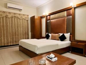 a hotel room with a bed and a table at The Grand Hotel Multan in Multan