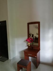 a dresser with a mirror and a vase of flowers on it at Solitary Resort in Ella