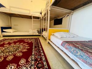 a bedroom with two bunk beds and a rug at Hostel Go And Stay Jaisalmer in Jaisalmer